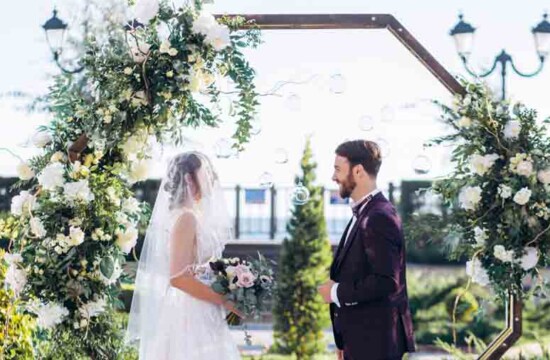 Homem e mulher se casando num evento com tendência de grama sintética