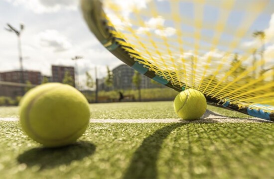 Tênis com grama esportiva de material sintético.